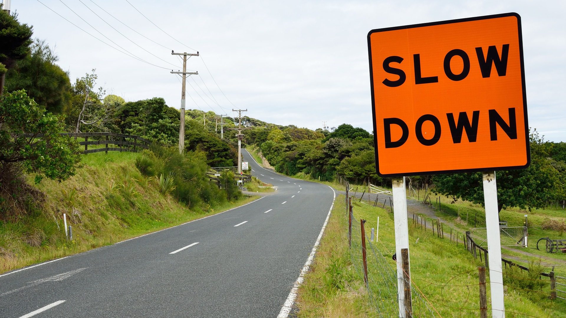 A road with a "slow down" sign. A symbol of pacing and rest for long covid