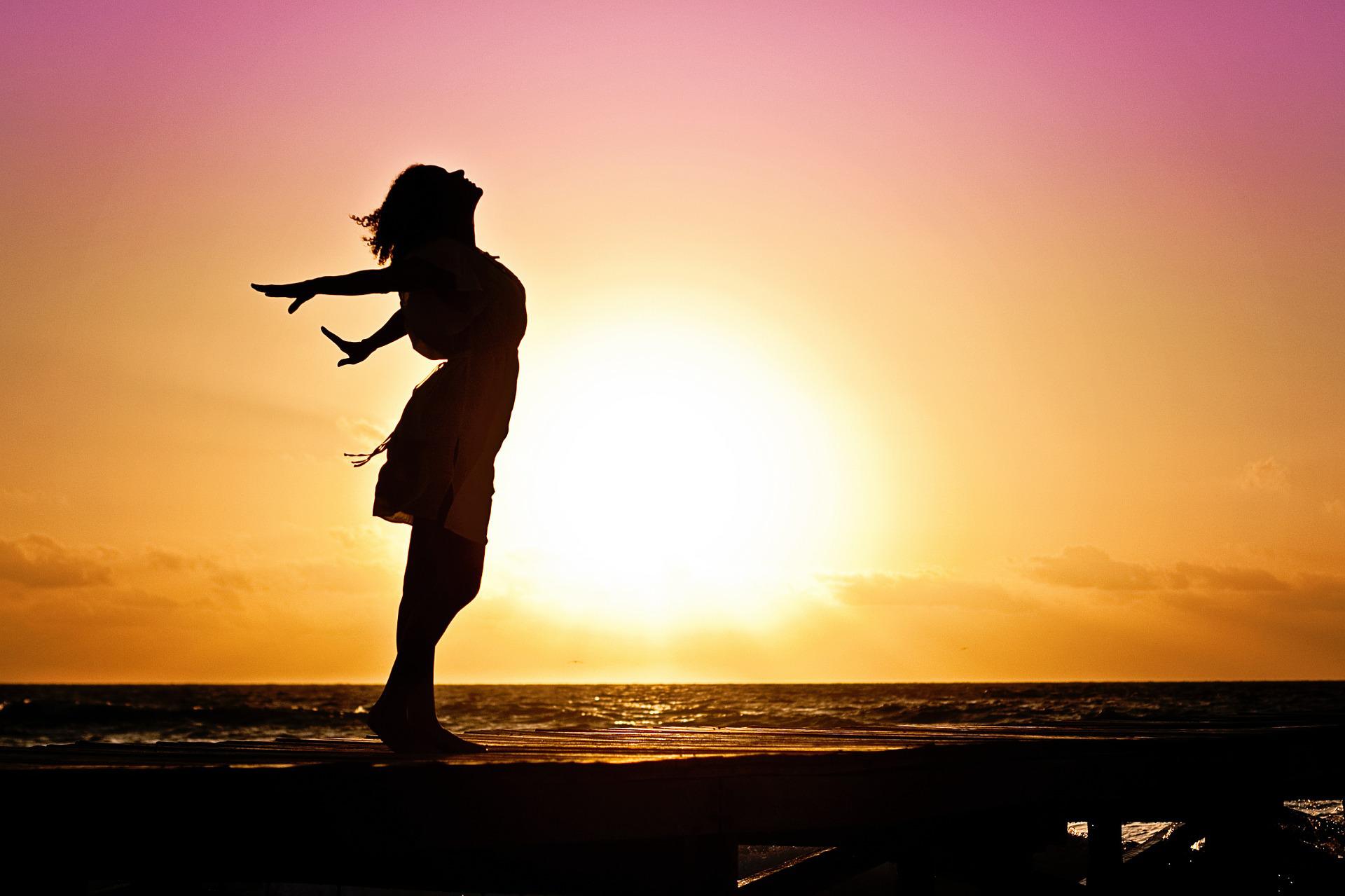 Woman enjoying sunset looking joyous, symbolising recovery from Long Covid